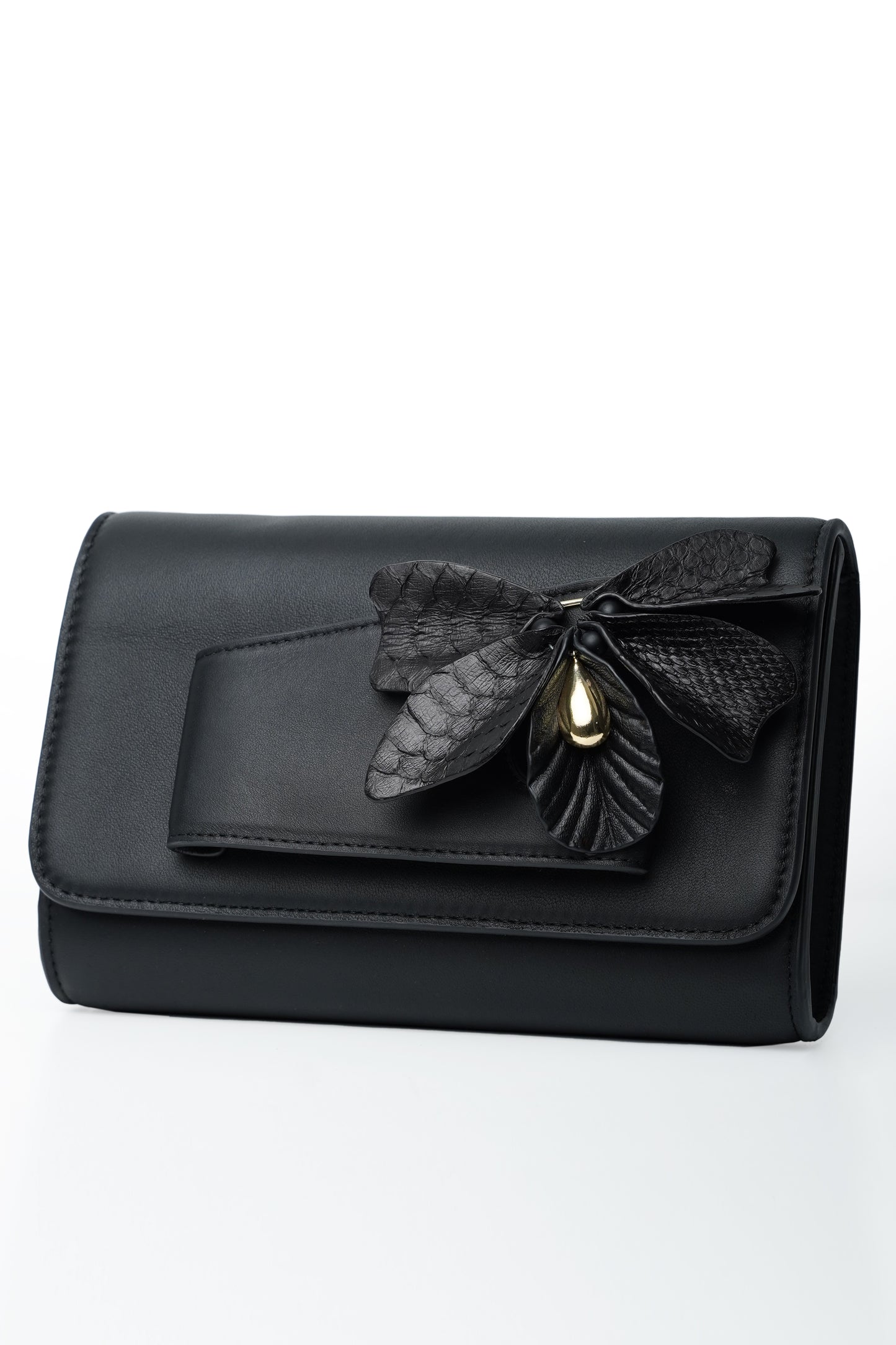 Black butterfly handbag made of python and cowhide leather with floral detail.