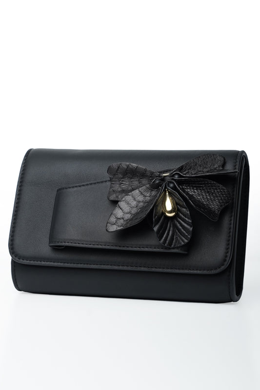 Black butterfly handbag made of python and cowhide leather with floral detail.