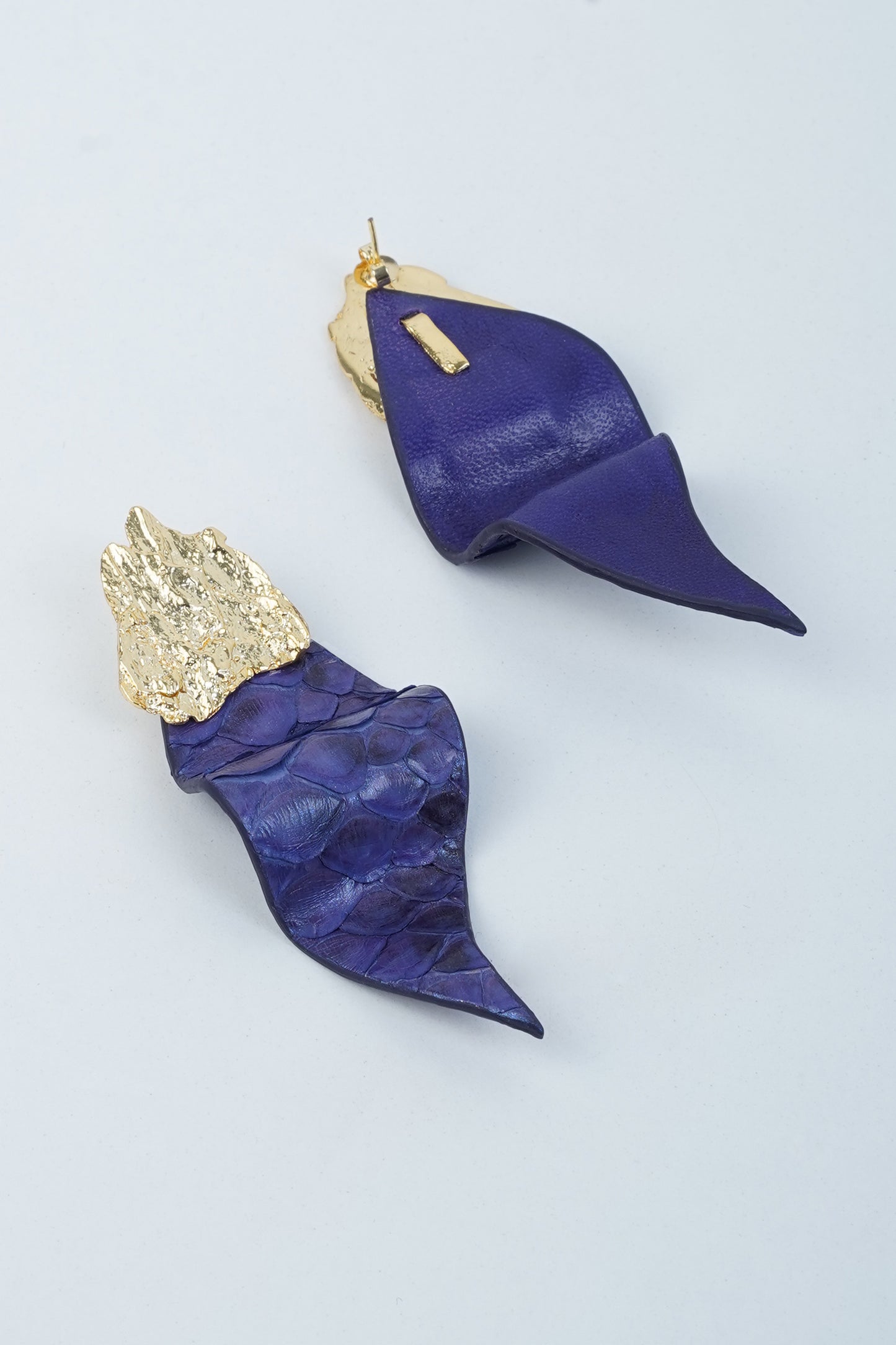 Purple eucalyptus leaf earrings with sculpted leather design and brass accent detail.
