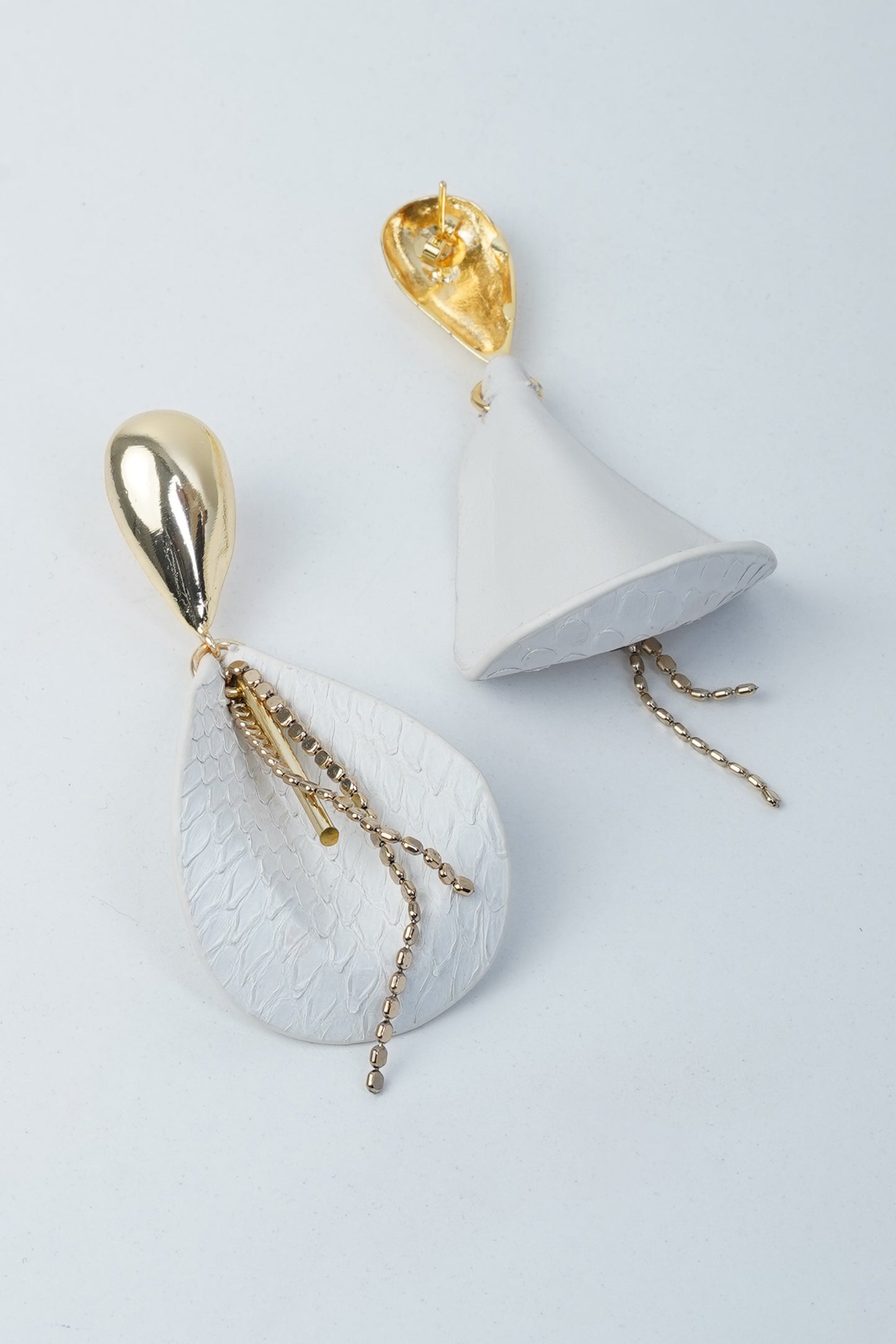 White leather drop earrings with gold-plated flower and leaf brass accents