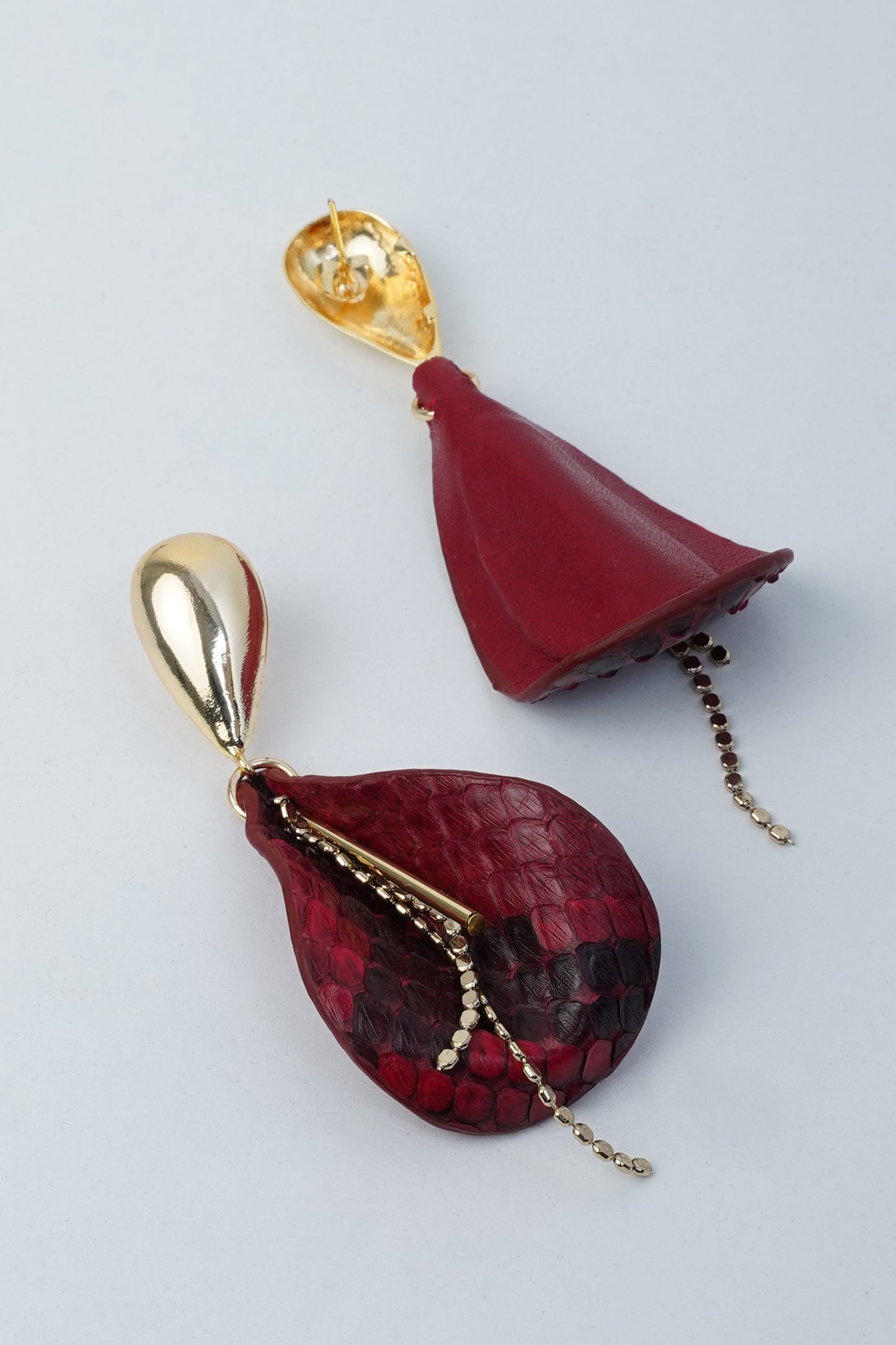 Burgundy drop earrings with exotic leather texture and gold-plated brass flower and leaf elements