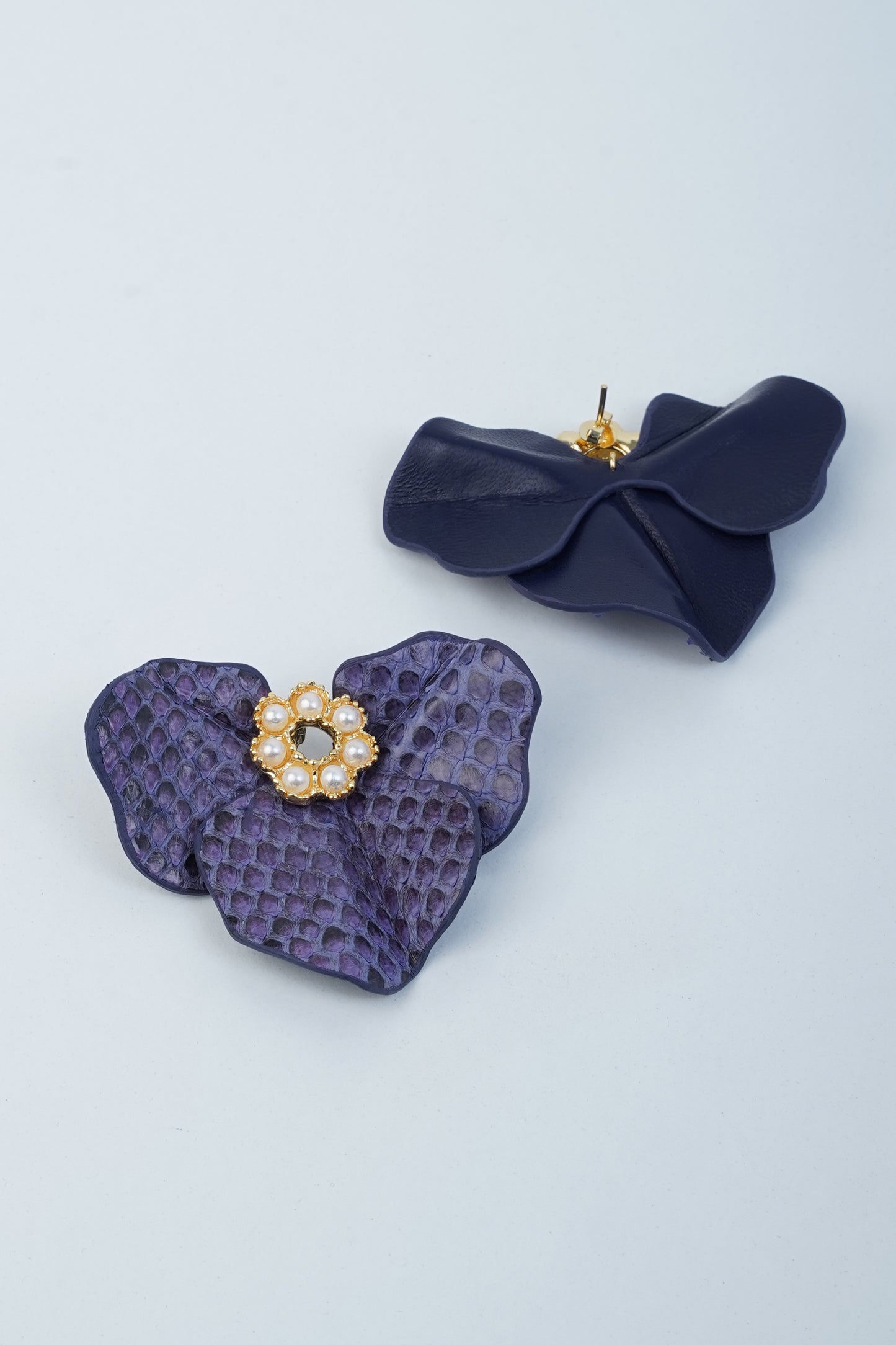 Dark blue leather Geranium Flower Earrings with gold-plated center and pearl ornament details, featuring an exotic and natural texture.