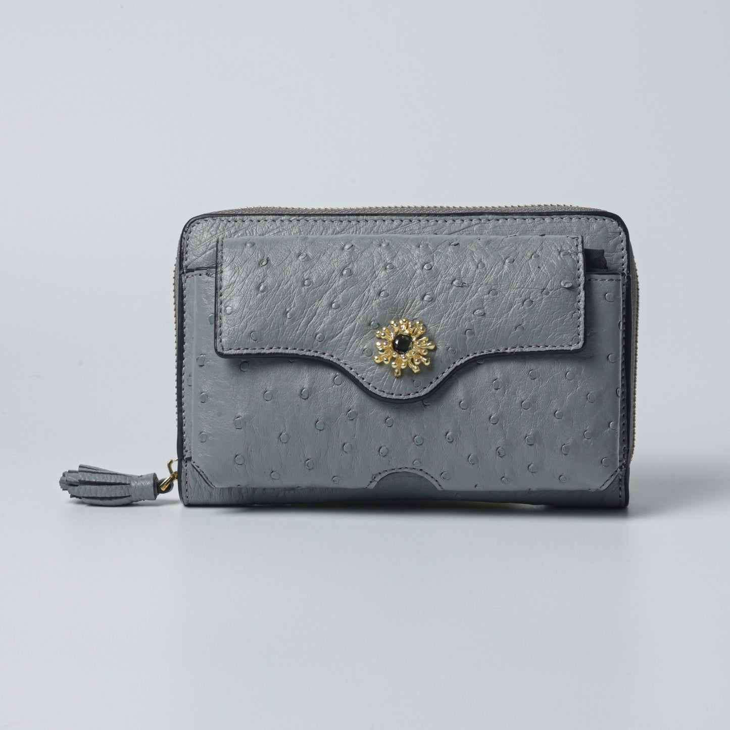 Handmade raspberry color ostrich leather clutch bag with gold-plated brass details and elegant chain strap.